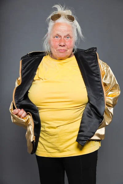 Cool femme âgée portant une veste dorée. Cheveux longs et gris. Lunettes de soleil. Prise de vue. Isolé . — Photo
