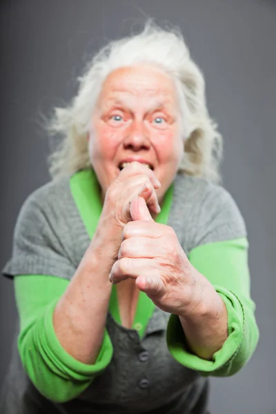 Mujer mayor de pelo gris blanco con expresiva cara emocional y manos. Estudio plano aislado sobre fondo gris . — Foto de Stock