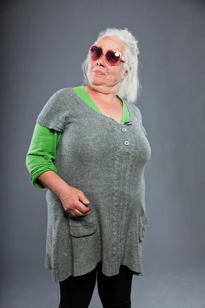 Idősebb nő és kifejező arc napszemüveget visel. vicces. stúdió felvétel elszigetelt a szürke háttér. — Stock Fotó