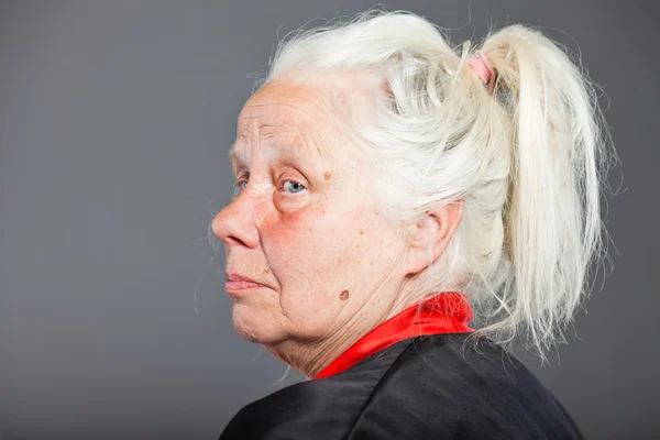 Старша жінка з довгим сірим волоссям в чорно-червоному кімоно. Студійний знімок ізольовано на сірому фоні . — стокове фото