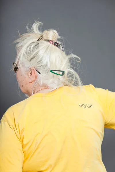 Задня голова старшої жінки з довгим сірим волоссям. Студійний знімок ізольовано на сірому фоні . — стокове фото