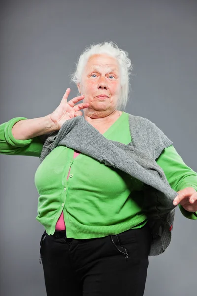 Divertente donna anziana espressiva. Si comporta da giovane. Studio girato isolato su sfondo grigio . — Foto Stock