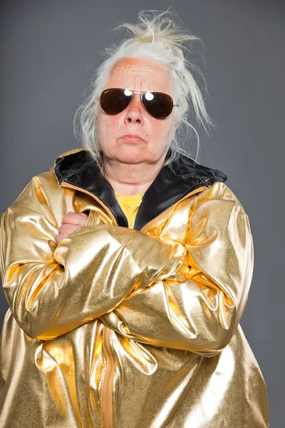 Donna anziana figa con giacca dorata. Capelli lunghi grigi. Occhiali. Colpo in studio. Isolato . — Foto Stock