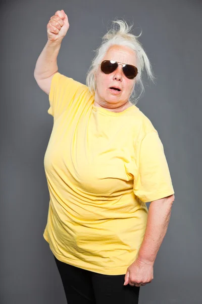 Hűvös hip idősebb nő, napszemüveg és a hosszú, szürke haj. kifejező arc. stúdió felvétel elszigetelt a szürke. — Stock Fotó
