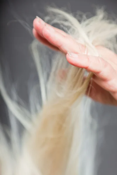 Närbild av hand senior kvinna i hår. Studio skott. isolerad på grå. — Stockfoto
