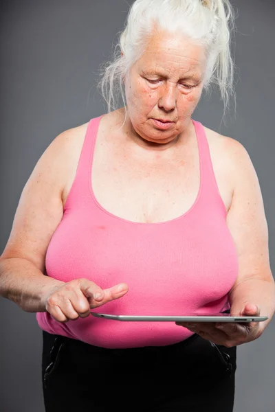 En eldre kvinne som holder tavle langt grått hår. Studio-opptak. Isolert på grå bakgrunn . – stockfoto