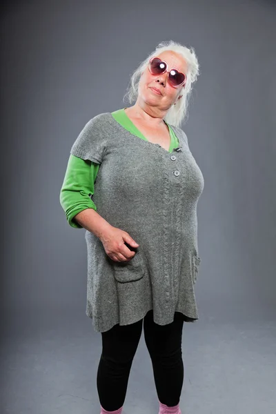 고위 여자 표현 얼굴로 선글라스를 착용 합니다. 재 밌 네요. 스튜디오 촬영에 고립 된 회색 배경. — 스톡 사진
