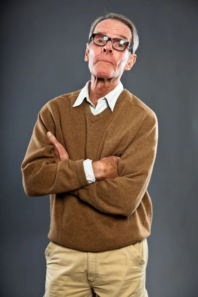 Ausdrucksstarker gut aussehender älterer Herr mit Brille vor grauer Wand. Witzig und charakteristisch. Gut angezogen. Studioaufnahme. — Stockfoto