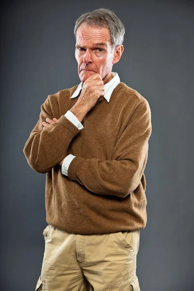 Espressivo bell'uomo anziano contro il muro grigio. Divertente e caratteristico. Ben vestita. Studio girato . — Foto Stock