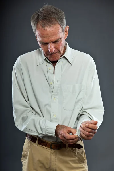 Expressieve goed uitziende senior man tegen grijze muur. Grappig en karakteristiek. Goed gekleed. Studioshoot. — Stockfoto