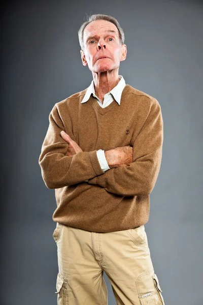 Uttrycksfull snygg senior man mot grå vägg. Roligt och karaktäristiskt. Välklädd. Studioinspelning. — Stockfoto