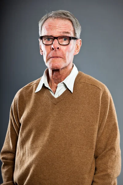 Expresivní dobře vypadající starší muž nosí brýle proti šedé zdi. zábavný a charakteristické. dobře oblečený. Studio záběr. — Stock fotografie