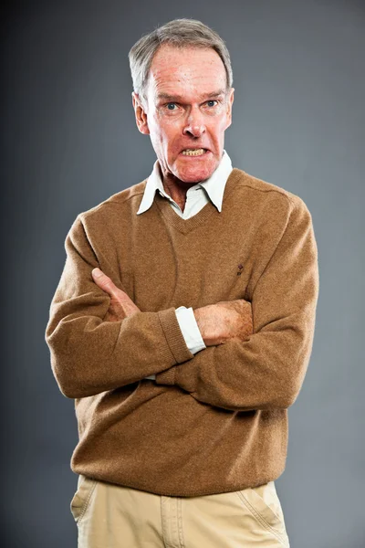 Ausdrucksstarker gut aussehender älterer Herr vor grauer Wand. Witzig und charakteristisch. Gut angezogen. Studioaufnahme. — Stockfoto