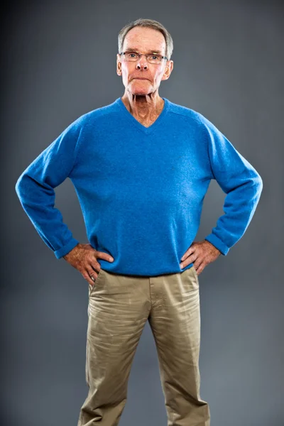 表現力豊かな良い灰色の壁に対してシニア男性を探しています。面白いと特性。よく服を着てください。青いセーター。スタジオ撮影. — ストック写真