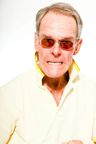Uttrycksfulla bra söker senior mannen ledig sommar klädd mot vit vägg. bär solglasögon. glada, roliga och karakteristiska. isolerade. Studio skott. — Stockfoto
