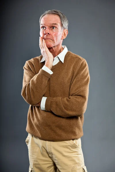 Expressive good looking senior man against grey wall. Funny and characteristic. Well dressed. Studio shot. — Stock Photo, Image