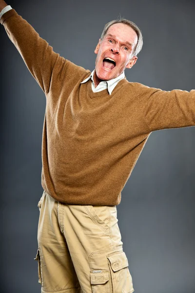 Выразительный симпатичный пожилой человек против серой стены. Забавно и характерно. Хорошо одет. Снимок студии . — стоковое фото