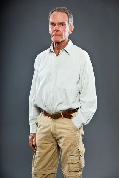 Homem idoso expressivo e bonito contra a parede cinzenta. Engraçado e característico. Bem vestida. Estúdio . — Fotografia de Stock