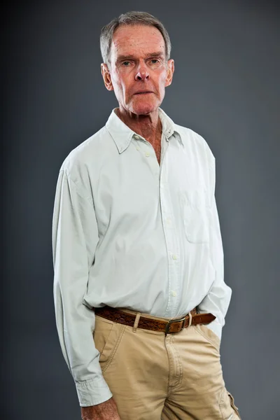 Hombre mayor expresivo y bien parecido contra la pared gris. Gracioso y característico. Bien vestido. Captura de estudio . —  Fotos de Stock