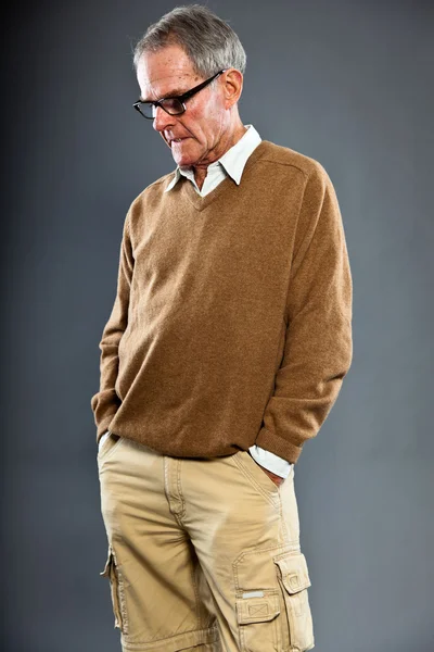 Hombre mayor expresivo y guapo que usa anteojos contra la pared gris. Gracioso y característico. Bien vestido. Captura de estudio . — Foto de Stock