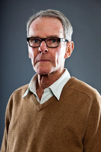 Expressive beau senior homme portant des lunettes contre le mur gris. Drôle et caractéristique. Bien habillé. Plan studio . — Photo