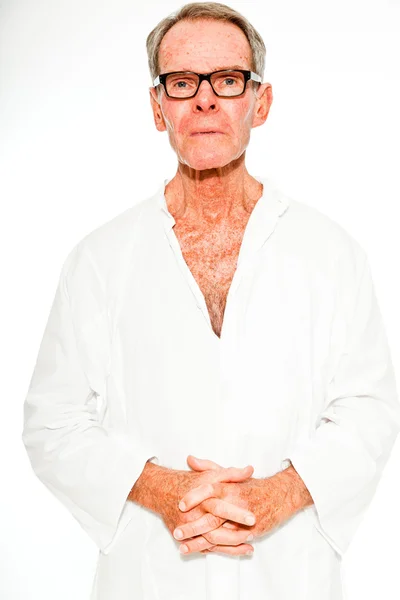 Выразительный, хорошо выглядящий пожилой мужчина, одетый в летнее платье, прислонившееся к белой стене. В очках. Счастливый, духовный и характерный. Изолирована. Снимок студии . — стоковое фото