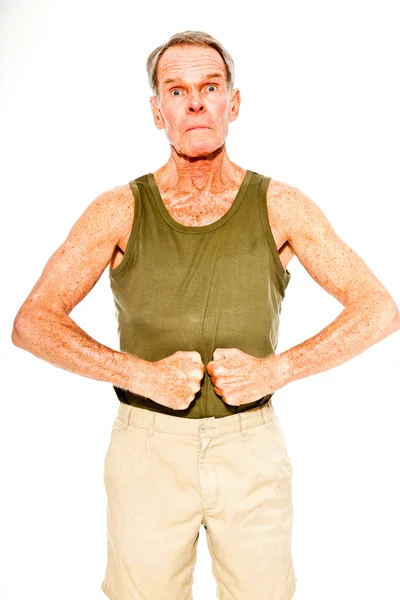 Sportovní dobře vypadající starší muž příležitostné letní oblečení proti bílé zdi. cvičit svaly. šťastný, zábavný a charakteristické. izolovaný. Studio záběr. — Stock fotografie