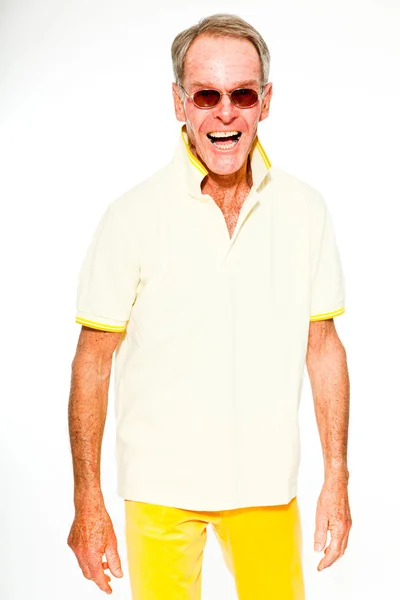 Ausdrucksstarker gut aussehender älterer Herr, lässig sommerlich gekleidet vor weißer Wand. mit Sonnenbrille. glücklich, lustig und charakteristisch. Vereinzelt. Studioaufnahme. — Stockfoto