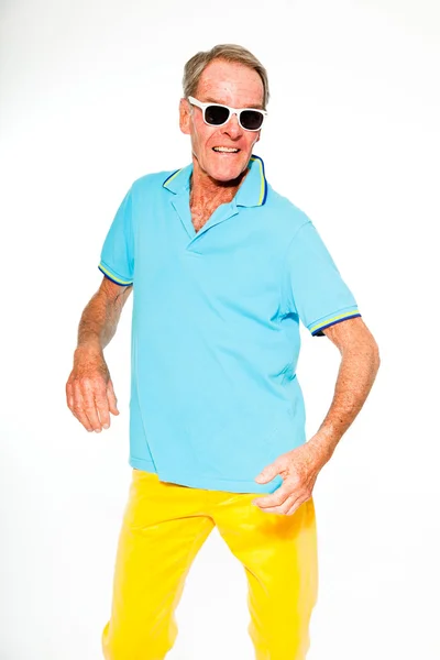 Expressieve goed uitziende senior man casual zomer gekleed tegen witte muur. dragen van een zonnebril. Gelukkig, grappige en karakteristiek. geïsoleerd. studio opname. — Stockfoto
