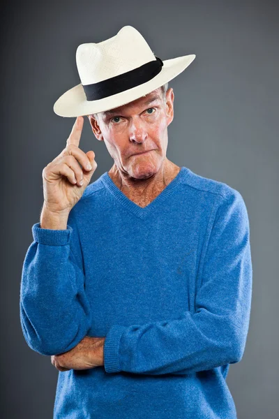 Wyraziste, dobrze wyglądający starszy człowiek ścianę szary. kapeluszu. zabawny i charakterystyczne. dobrze ubrany. niebieski sweter. łapka. — Zdjęcie stockowe