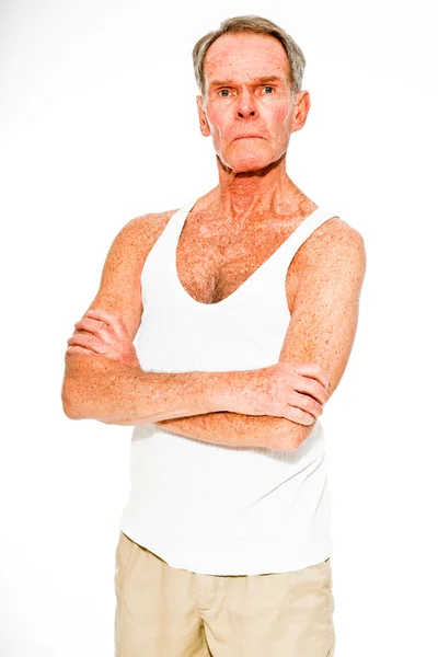 Ausdrucksstarker gut aussehender älterer Herr, lässig sommerlich gekleidet vor weißer Wand. glücklich, lustig und charakteristisch. Vereinzelt. Studioaufnahme. — Stockfoto