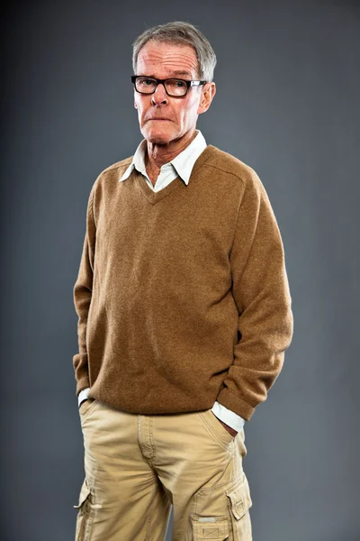 Uttrycksfulla god söker äldre man glasögon mot grå vägg. rolig och karakteristiska. välklädd. Studio skott. — Stockfoto