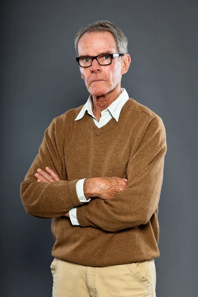 Expressive good looking senior man wearing glasses against grey wall. Funny and characteristic. Well dressed. Studio shot. — Stock Photo, Image