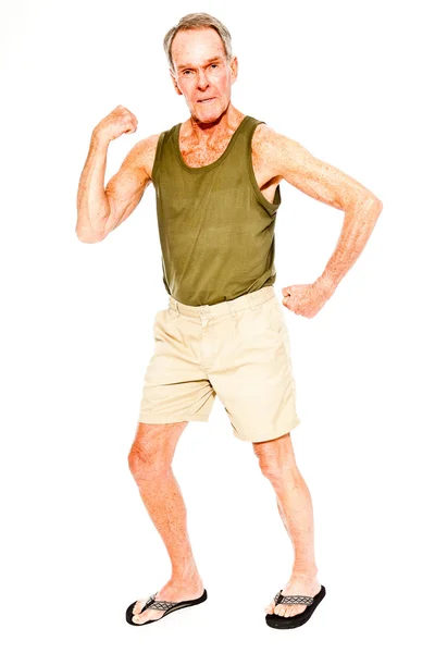 Atlético de buen aspecto hombre mayor verano casual vestido contra la pared blanca. Ejercitando sus músculos. Feliz, divertido y característico. Aislado. Captura de estudio . — Foto de Stock
