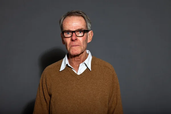 Expressive beau senior homme portant des lunettes contre le mur gris. Drôle et caractéristique. Bien habillé. Plan studio . — Photo