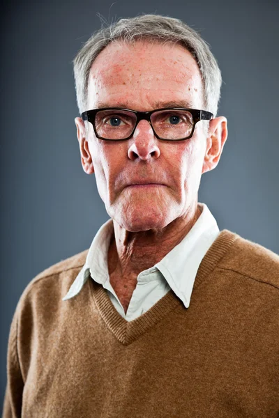 Uttrycksfulla god söker äldre man glasögon mot grå vägg. rolig och karakteristiska. välklädd. Studio skott. — Stockfoto