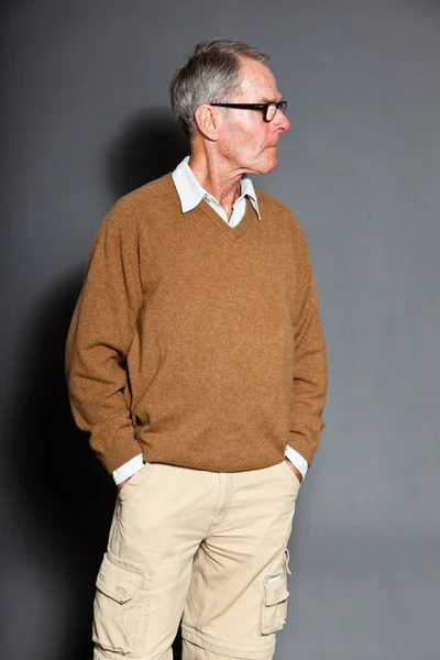 Ekspresyjny dobry starszy mężczyzna w okularach szarej ścianie. zabawny i charakterystyczne. dobrze ubrany. łapka. — Zdjęcie stockowe