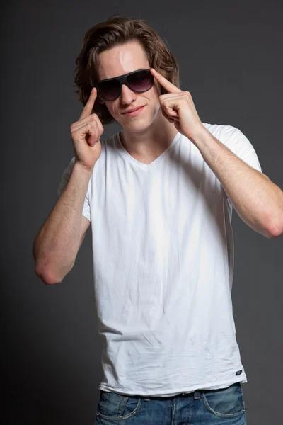 갈색 긴 머리와 선글라스 회색 배경에 고립 된 잘생긴 젊은 남자. 패션 스튜디오 촬영. — 스톡 사진