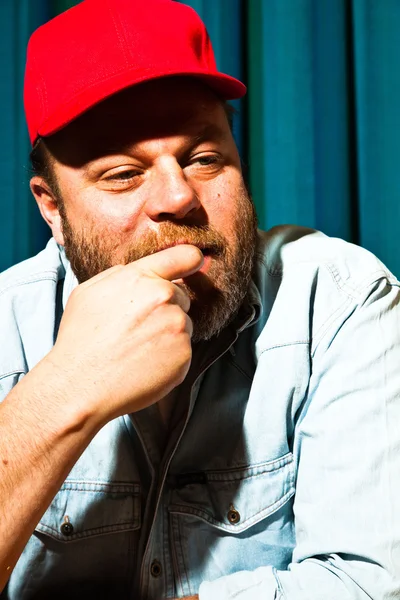 Homem com barba e boné vermelho. Retrato de um camionista . — Fotografia de Stock