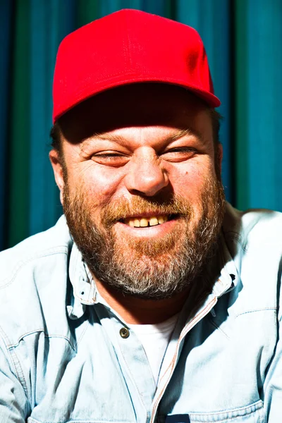 Mannen med skägg och röd mössa. porträtt av en trucker. — Stockfoto