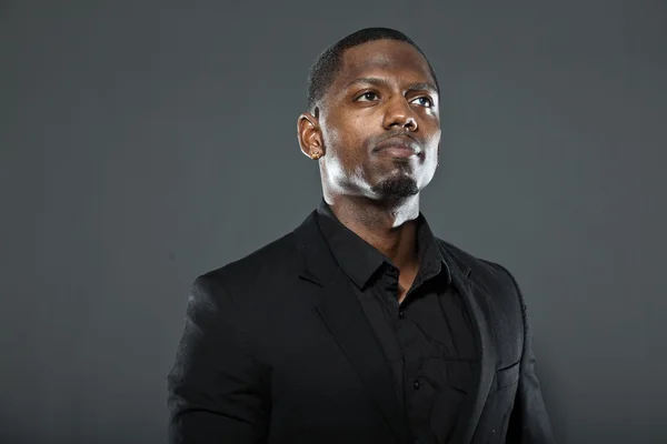 Cool black american man in dark suit. Studio fashion shot isolated on grey background. — Stock Photo, Image