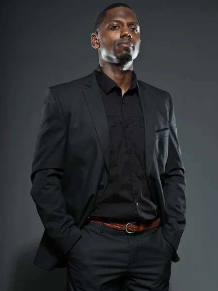 Hombre americano negro fresco en traje oscuro. Estudio de tiro de moda aislado sobre fondo gris . —  Fotos de Stock