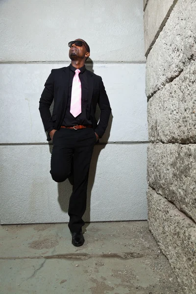 Serin siyah Amerikalı adam koyu elbiseli güneş gözlüğü takıyor. kentsel ortamda ateş moda. — Stok fotoğraf