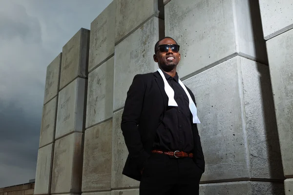 Cool black american man in dark suit wearing sunglasses. Fashion shot in urban setting. — Stock Photo, Image