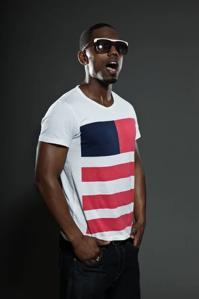 Cool urbano elegante hombre negro americano. Retrato de estudio de moda aislado sobre fondo gris. Usar gafas de sol oscuras . — Foto de Stock