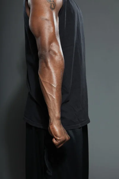 Brazo musculoso del hombre negro americano. Jugador de baloncesto. Estudio plano aislado sobre fondo gris . —  Fotos de Stock