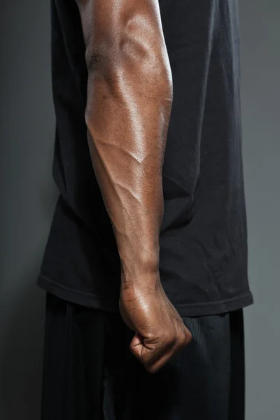 Muscled arm of black american man. Basketball player. Studio shot isolated on grey background. — Stock Photo, Image