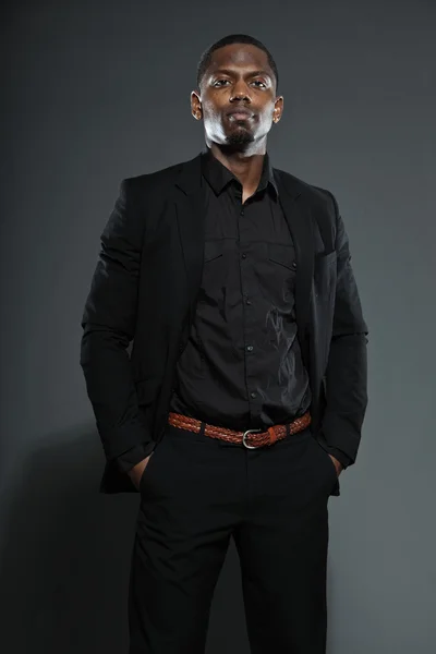 Serin siyah Amerikalı adam koyu takım elbiseli. studio moda izole üzerinde gri arka plan vurdu. — Stok fotoğraf