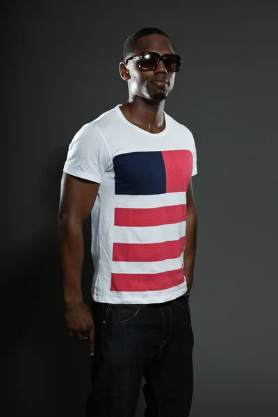 Fajny miejski stylowy czarny Amerykanin. portret studio moda na białym tle na szarym tle. nosi ciemne okulary. — Zdjęcie stockowe
