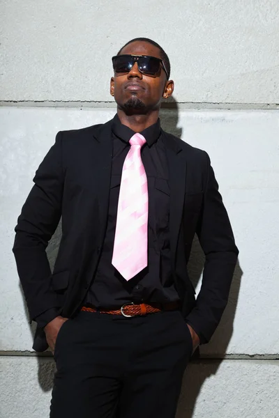 Cool black american man in dark suit wearing sunglasses. Fashion shot in urban setting. Royalty Free Stock Photos